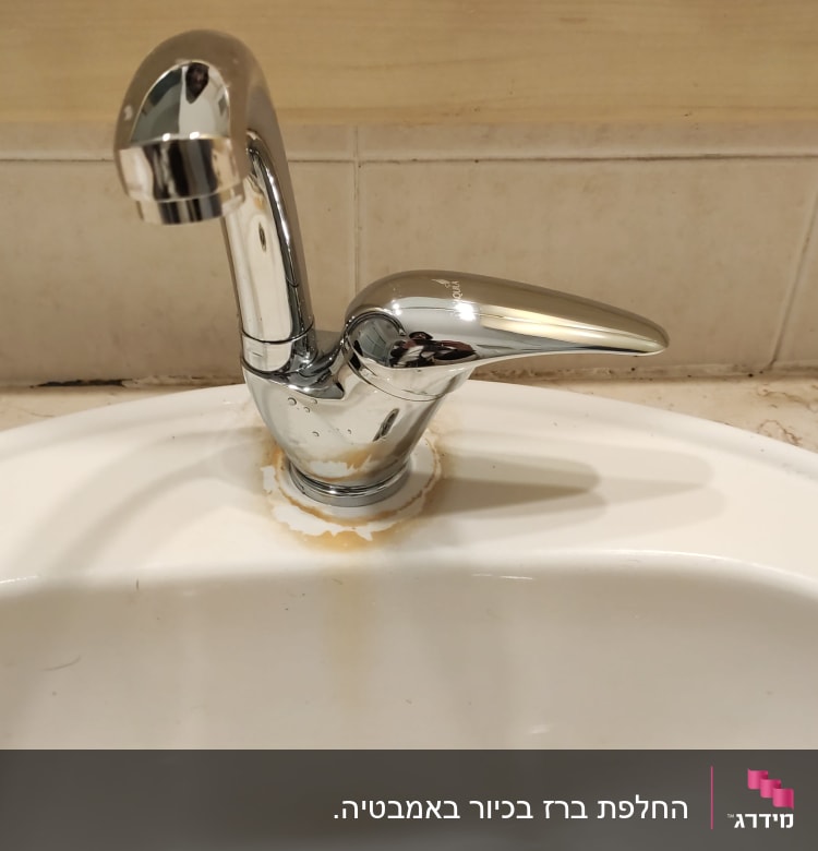 ברז כרום עם כתמי חלודה בכיור לבן